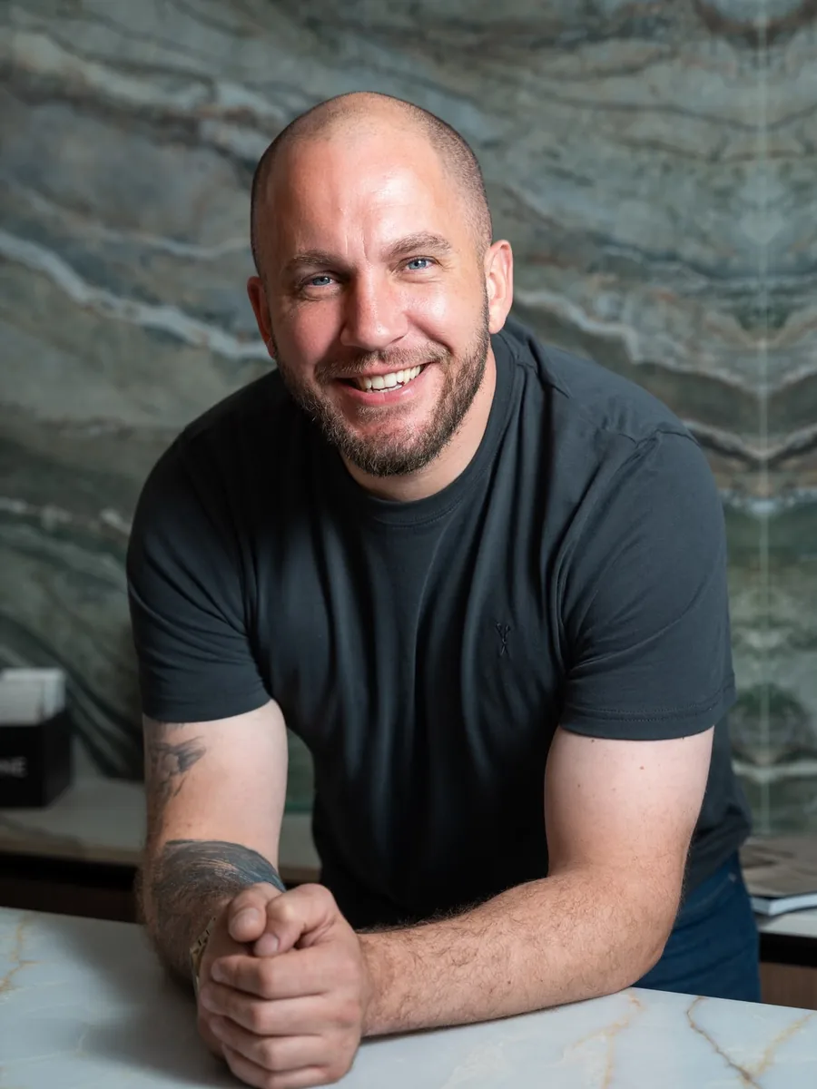 Chris Greenbank, founder of LM Stone Creative, leaning on a stone worktop